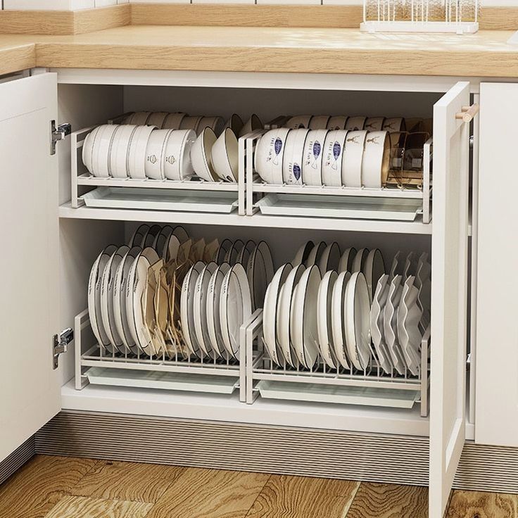 a cabinet filled with lots of white plates and silverware next to a counter top