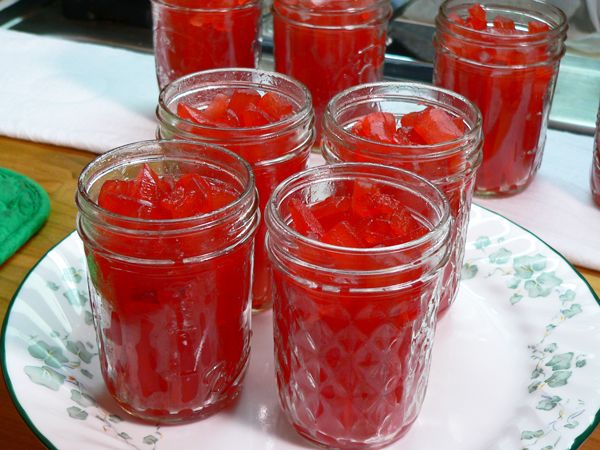 several jars filled with jelly sitting on top of a white plate