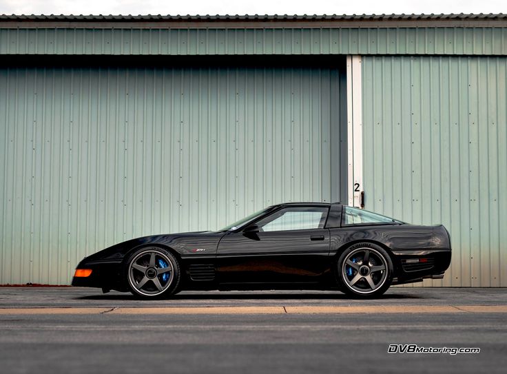 a black sports car parked in front of a building