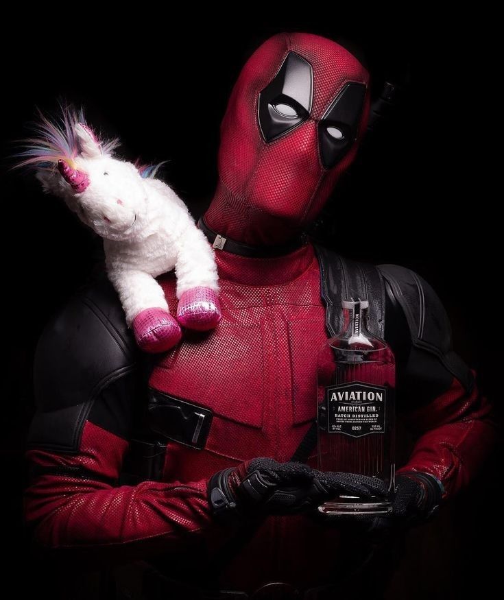 a man in a deadpool costume holding a cat