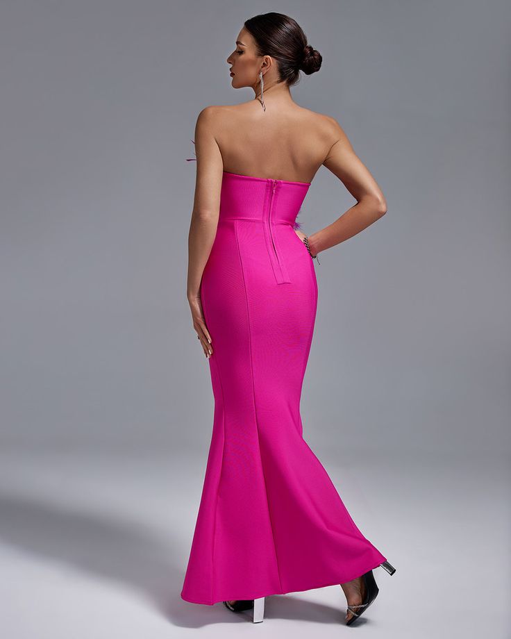 the back of a woman in a bright pink dress with her hands on her hips