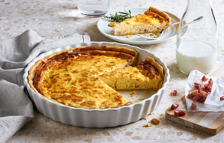 there is a pie on the table next to some milk and other dishes with utensils