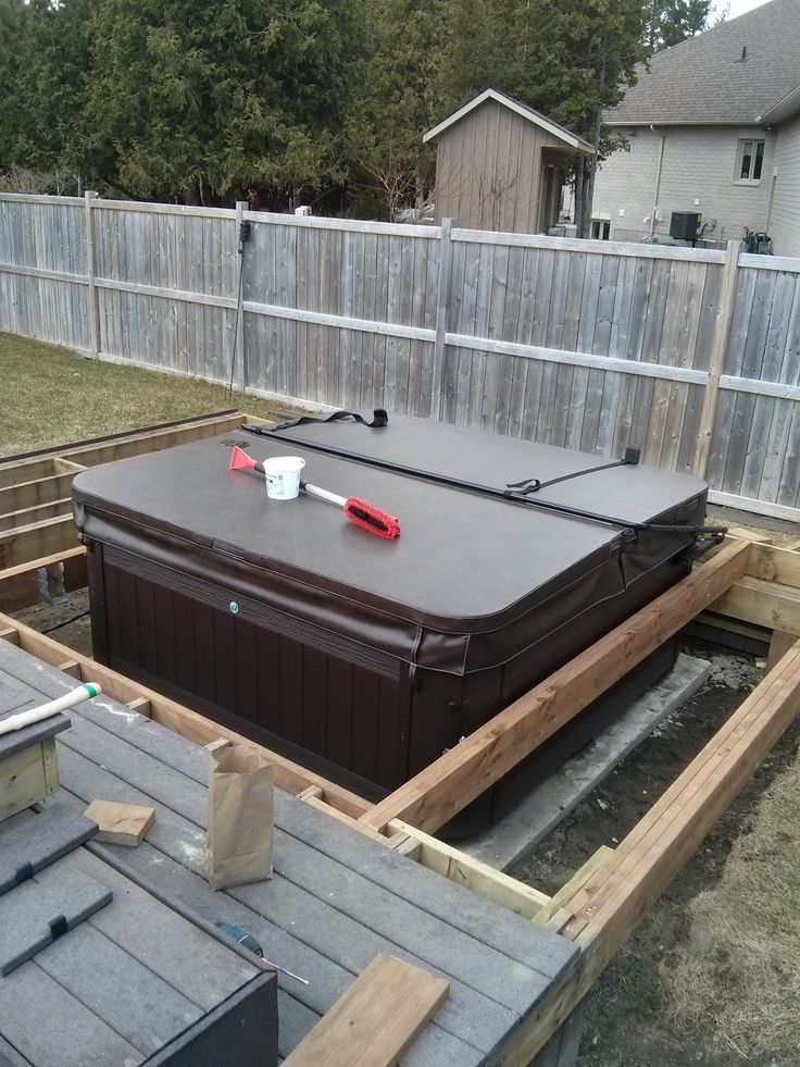 an in ground hot tub is being built on the back deck of a house,