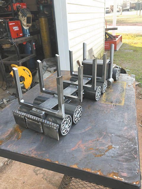 several metal objects sitting on top of a table in front of a garage with tools