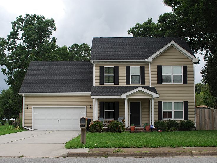 a two story house with black shutters and white trim on the front door is shown