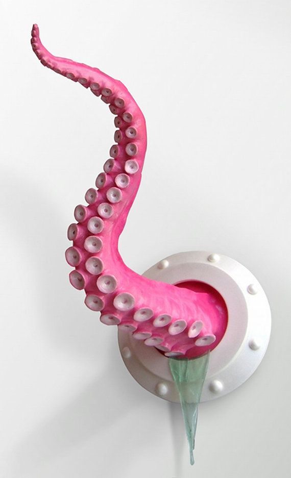 a pink and white octopus sculpture sitting on top of a wall