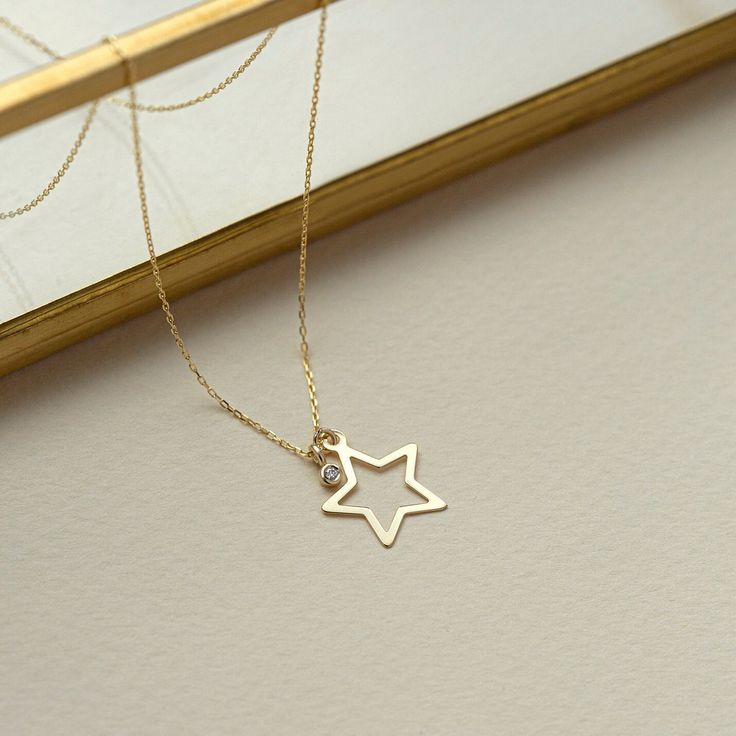 "1- P R O D U C T ∙  D E S C R I P T I O N Shine bright with this dazzling 14K Solid Gold Diamond Star Necklace for Women, featuringa  sparkling bezel diamond that adds a touch of celestial charm and elegance to any outfit. 2- P R O D U C T ∙  D E T A I L S Diamond Quality: * Diamond carat: 0.01 ct. * Clarity: VS2 * Color: F-G * Cut: Excellent cut * Diamond type: Natural Diamond  Setting Type: Bezel setting Gold material: 14K solid gold Choice of gold color: Yellow gold, Rose gold, White gold Ch Gold Star Pendant, Diamond Star Necklace, Star Necklace Gold, Star Pendant Necklace, Gold Diamond Necklace, Celestial Jewelry, Diamond Star, Handcrafted Necklace, Bezel Diamond