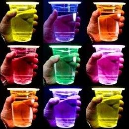 many different colored cups being held by hands