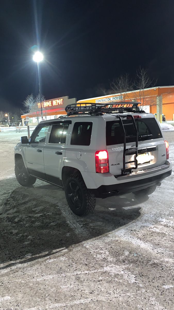 a white suv parked in the snow at night