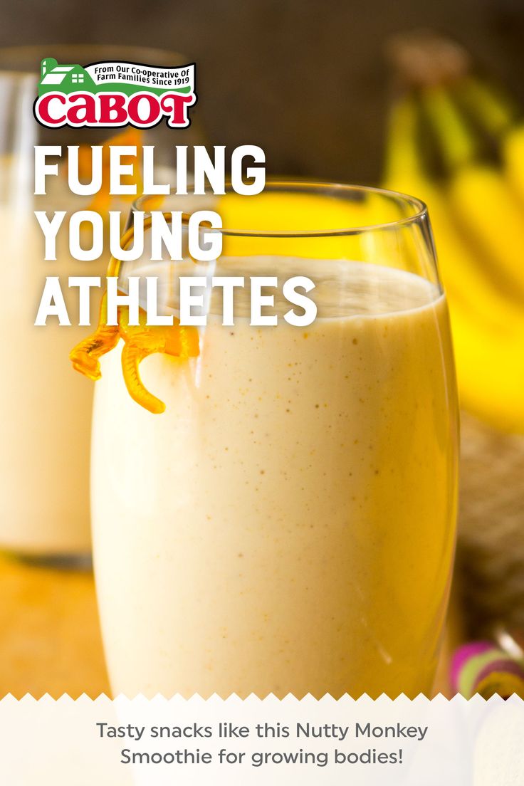 a close up of a glass of food on a table with bananas in the background