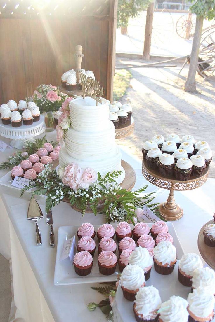 a table topped with lots of cupcakes and cakes