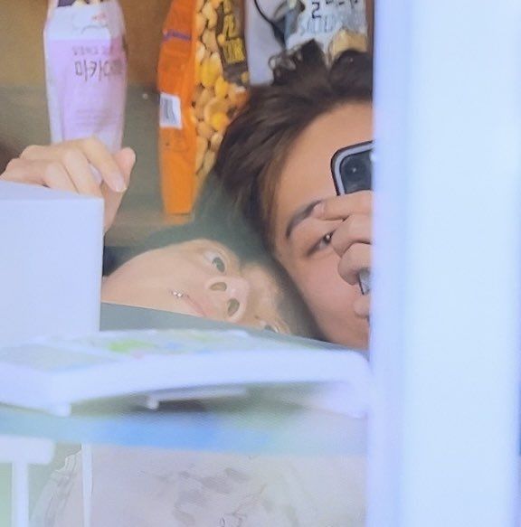 a woman taking a selfie in front of a mirror with her cell phone up to her face