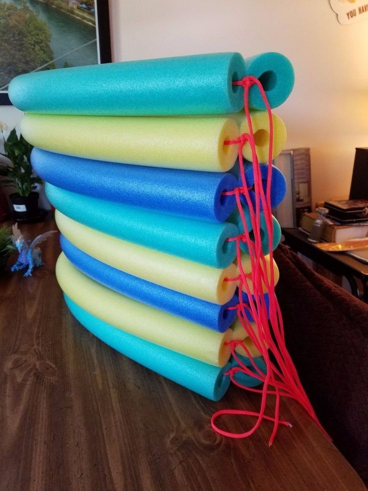 a stack of yoga mats sitting on top of a wooden table next to a lamp