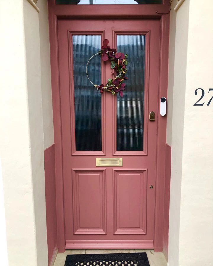 a pink front door with a wreath on it