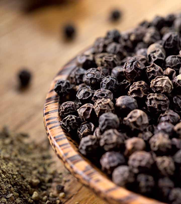 a wooden bowl filled with black pepper