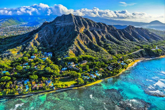 an aerial view of the ocean and mountains in hawaii, with houses on each side