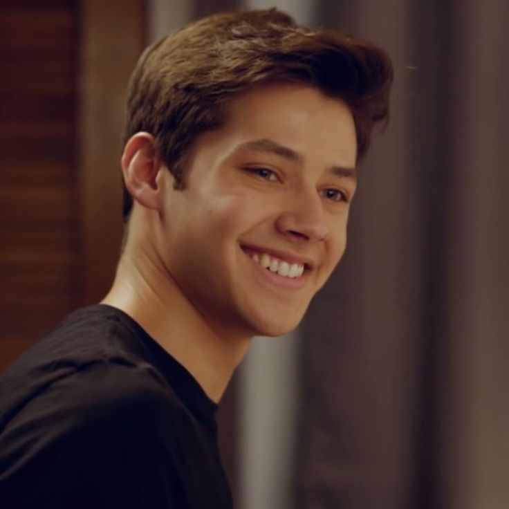 a young man smiling and wearing a black shirt