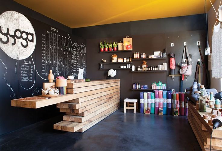 a coffee shop with chalkboard on the wall and shelves full of items in front of it