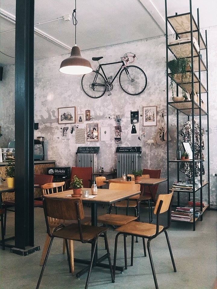 a dining room table with chairs and a bicycle mounted to the wall in front of it