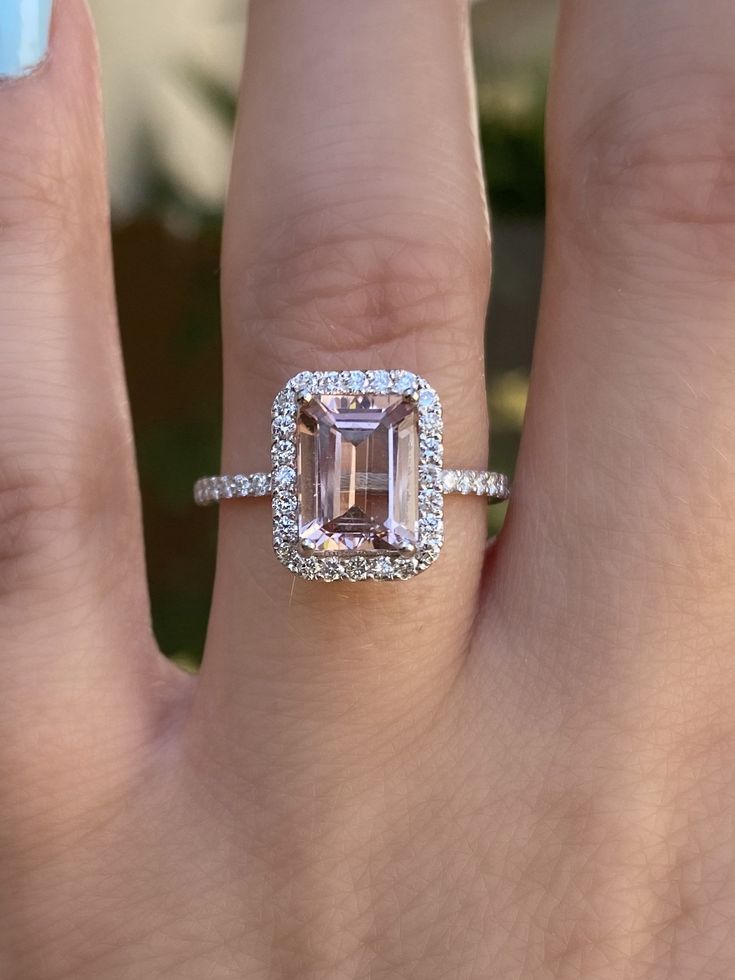 a woman's hand with a ring on it and an emerald stone in the middle