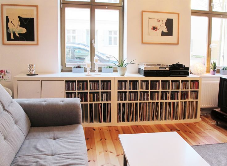 a living room filled with furniture and bookshelves in front of large open windows