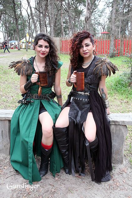 two women dressed in costumes sitting on a bench