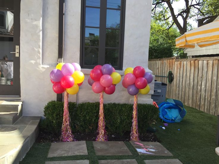 some balloons are in the grass near a house