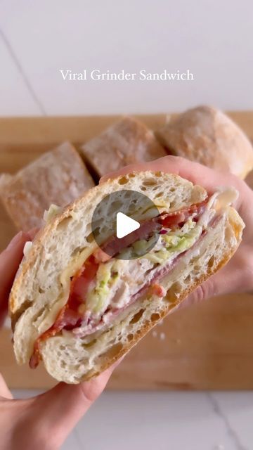 a person holding a sandwich in their hand with the words virtual grinder sandwich on it