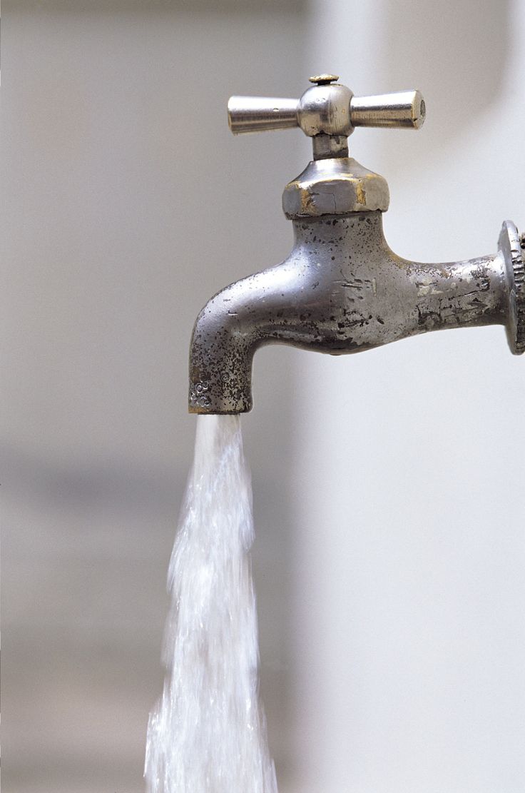 a faucet with water running from it's spout to the side