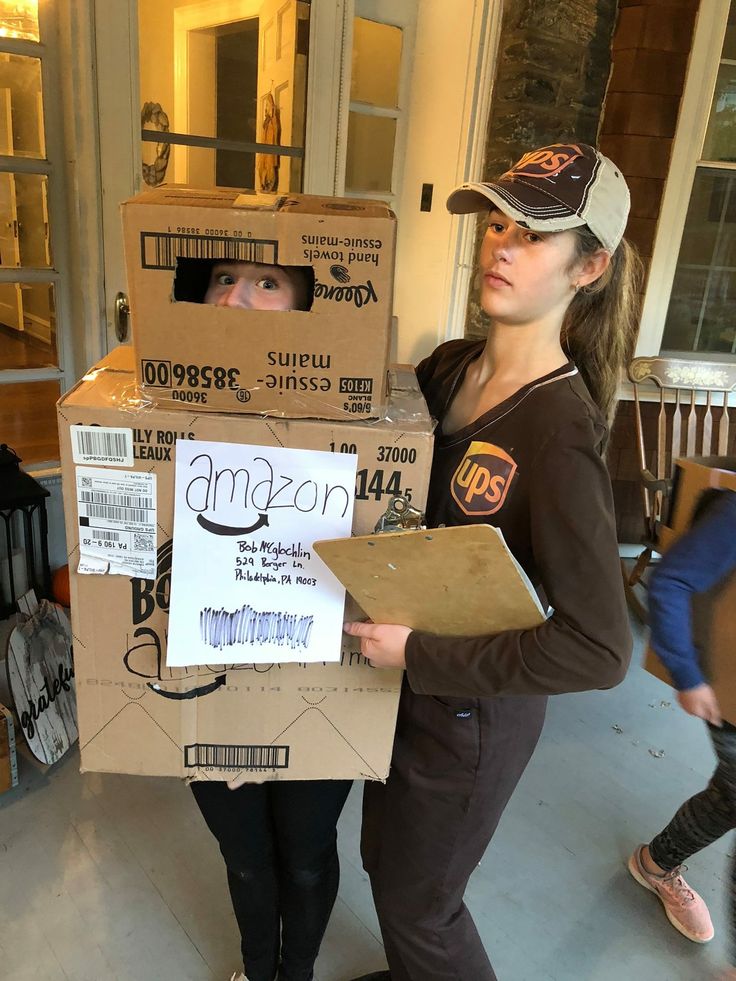 two girls are standing in front of boxes with amazon on them