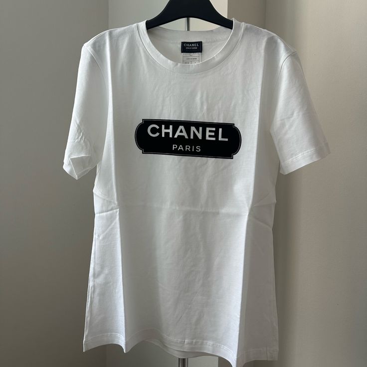 100 Authentic Chanel Uniform T-Shirt Size Xs Brand New White Crew Neck T-shirt With Designer Logo, Luxury White T-shirt With Letter Print, Designer White T-shirt With Logo, Luxury White Tops With Logo, Luxury White T-shirt With Logo Print, White Designer Logo T-shirt For Summer, White Designer Logo T-shirt, Casual White T-shirt With Designer Logo, White Designer Logo Short Sleeve T-shirt