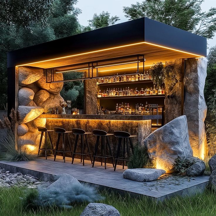 an outdoor bar is lit up at night with lights on and rocks in the foreground