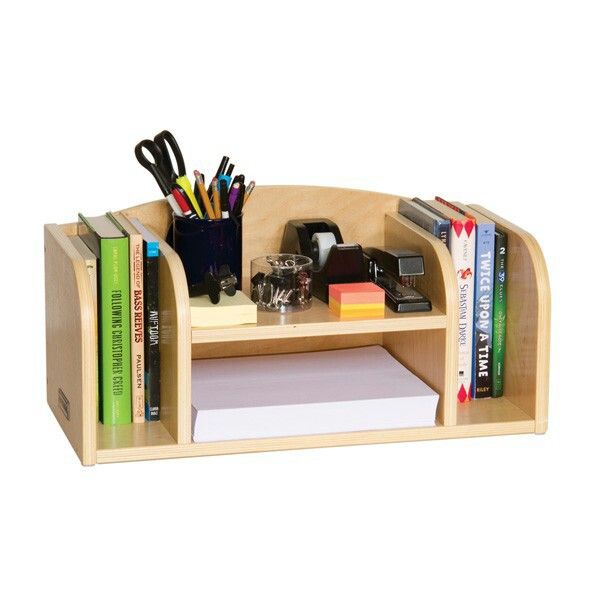 a wooden desk with books, pens and other office supplies on top of the shelf