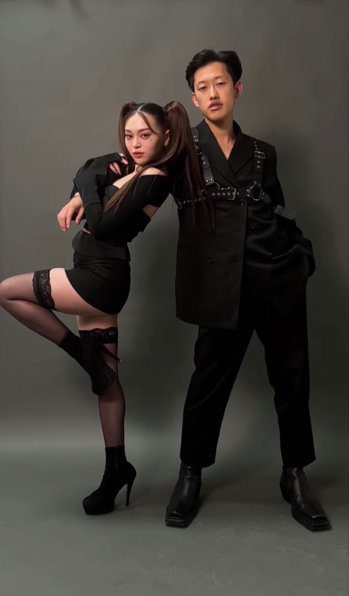 the man and woman are posing together for a photo in black outfits with high heels