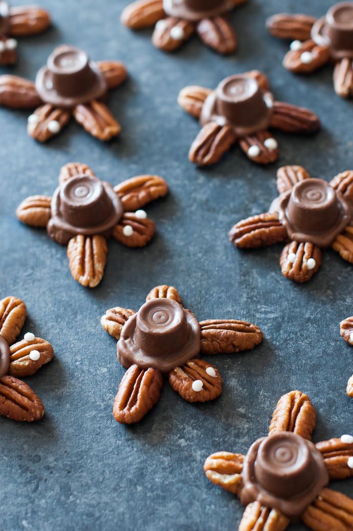 chocolate covered pretzels and pecans are arranged on a baking sheet