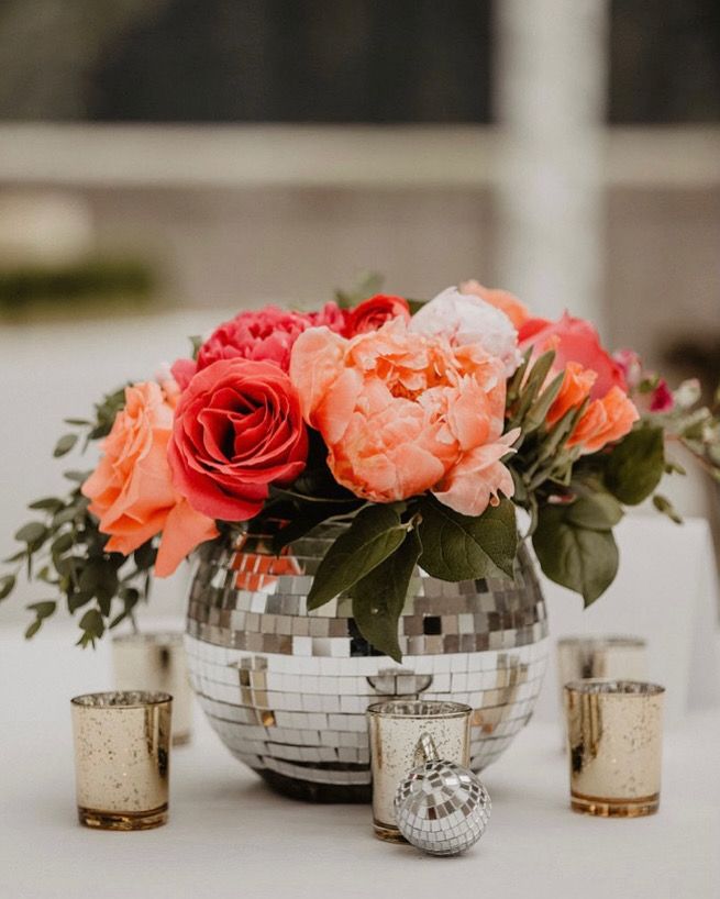 Disco ball vase at a June wedding with bright boho vibes Coral Theme Birthday Party, Disco Ball Flower Vase, Groovy Theme Centerpieces, Engagement Party Disco Theme, Disco Ball Planter Centerpiece, Flower Arrangements With Disco Balls, Mirrorball Centerpiece, Wedding Centerpieces Disco Ball, Disco Ball Floral Centerpiece