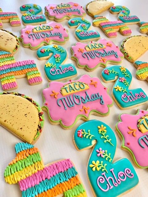 decorated cookies are arranged in the shape of numbers and letters on a white tablecloth