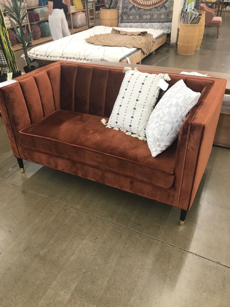 a couch with pillows on it in a store