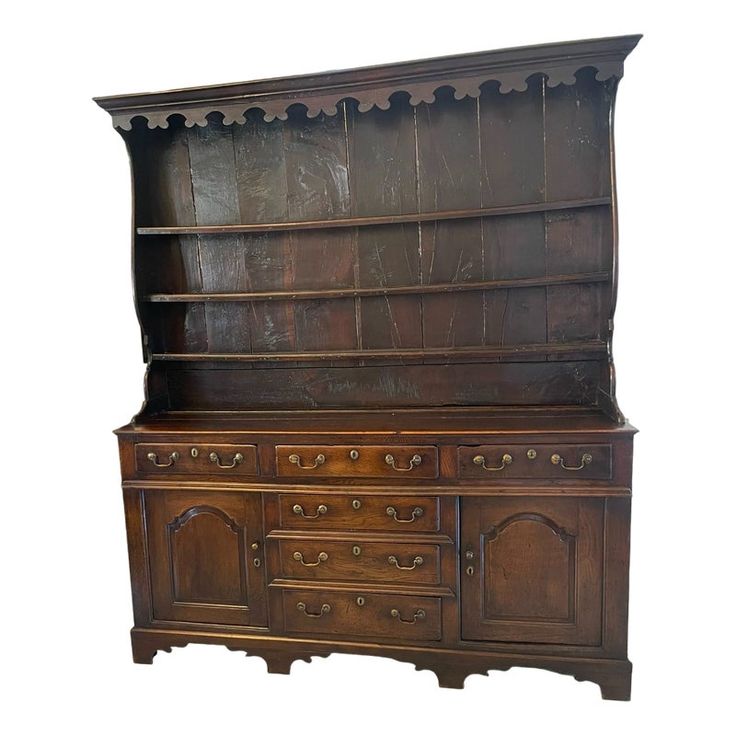 an old fashioned wooden dresser with drawers and cupboards on the top, against a white background