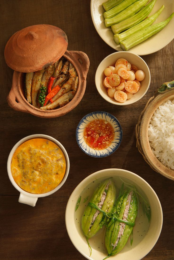 several bowls and plates with different foods in them sitting on a table top next to each other