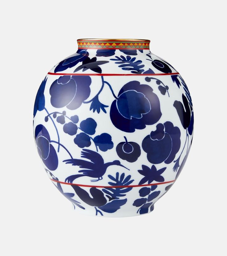 a blue and white vase with flowers painted on the front, sitting against a white background