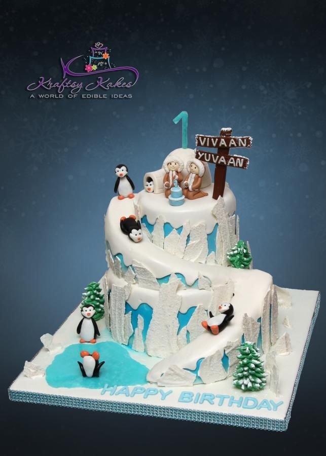 a birthday cake is decorated with penguins and snow