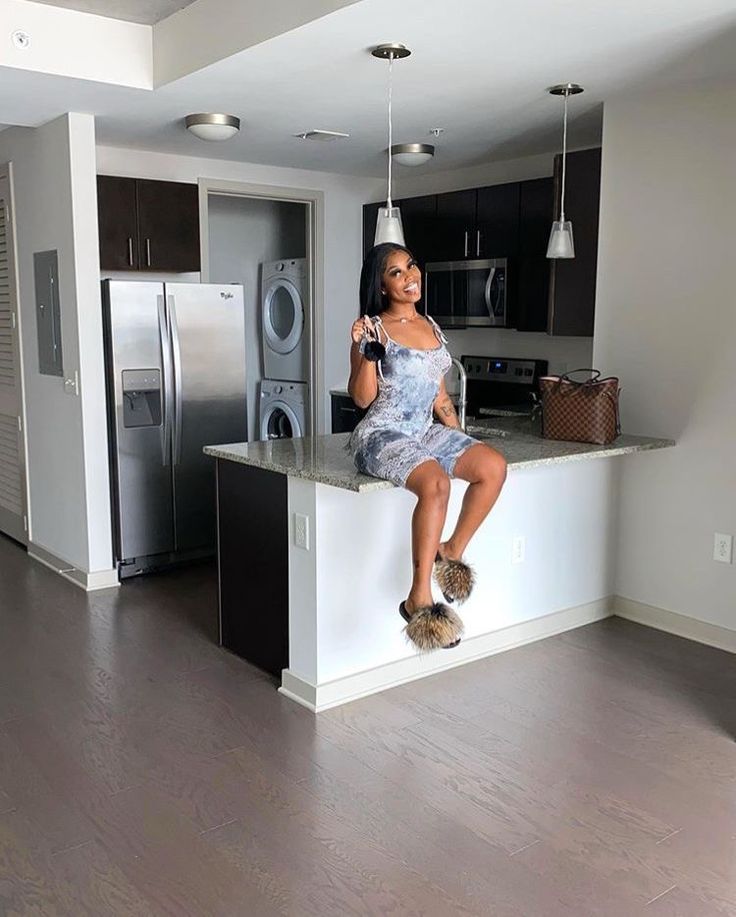 a woman sitting on top of a kitchen counter