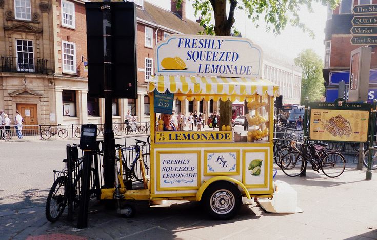 a lemonade stand on the side of a street