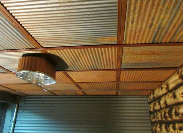 the ceiling is made out of corrugated and has a light fixture on top of it