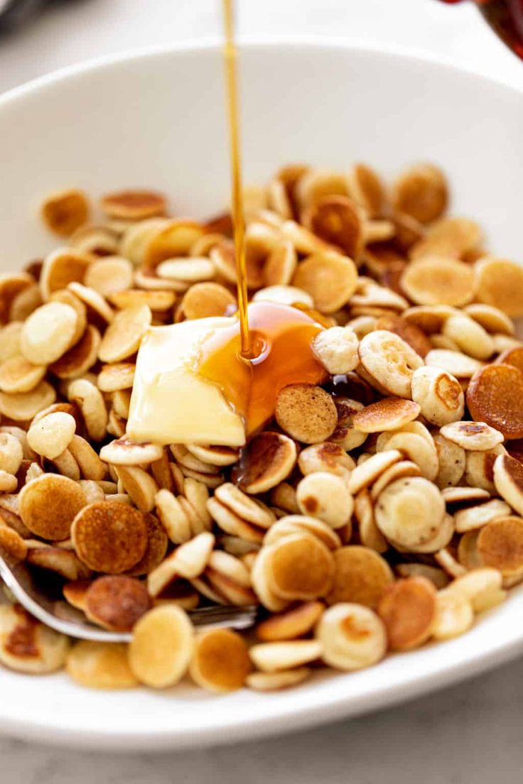 a bowl filled with nuts and honey being drizzled on top