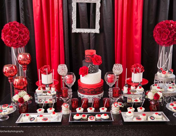 a red and white dessert table set up for a party