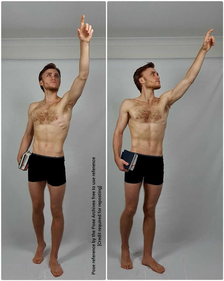 a man with no shirt is standing in front of a white background and holding his hand up