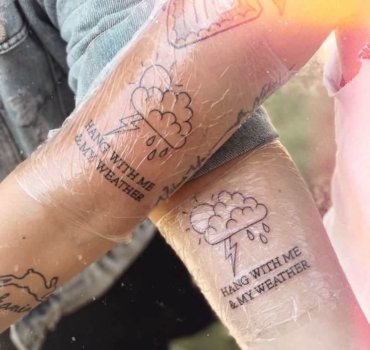 two people with matching tattoos on their arms