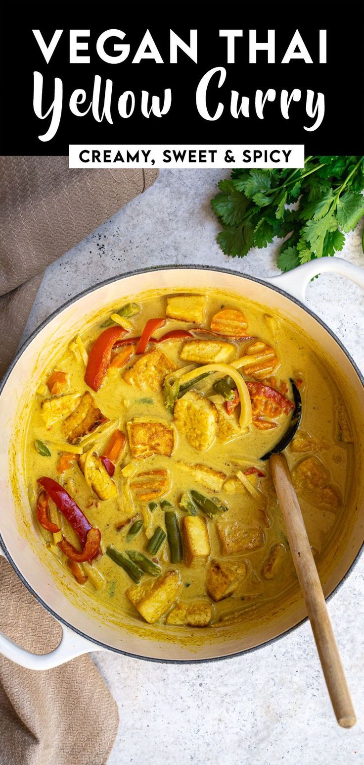 vegan thai yellow curry in a white bowl with a wooden spoon next to it